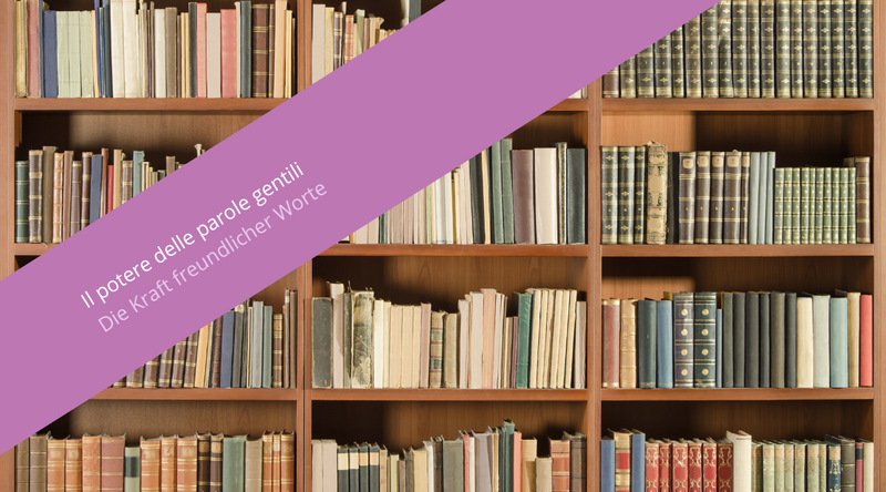 Auf dem Bild ist ein Regal voller Bücher zu sehen. Über dem Bild ist ein violetter Schriftzug mit der Aufschrift „Il potere delle parole gentili. Die Kraft freundlicher Worte“ zu sehen.