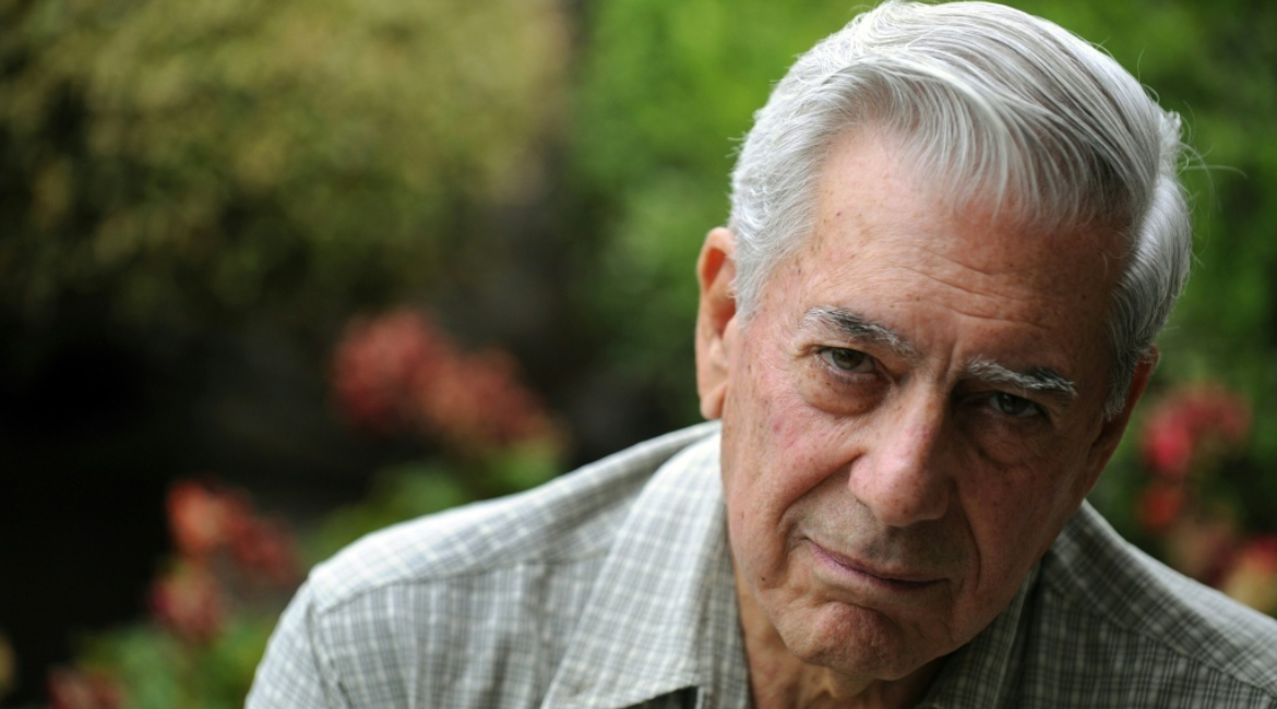 Nahaufnahme von Mario Vargas Llosa vor der Hintergrund eines Blumengartens.