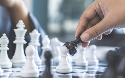 Zwei Hände spielen Schach. Eine Hand bewegt einen schwarzen Bauern. Zwei Hände spielen Schach. Eine Hand bewegt einen schwarzen Bauern.